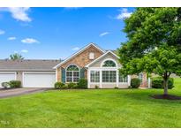 Charming home with stone accents, lush lawn, and mature tree on a beautiful, sunny day at 342 Faith Dr, Gibsonville, NC 27249