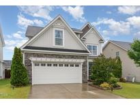 Charming home with a stone facade and a two-car garage, complemented by a well-manicured lawn at 3904 Freemark Ln, Fuquay Varina, NC 27526