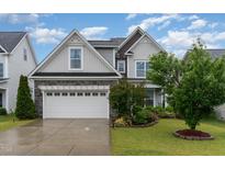 Charming two-story home featuring stone accents, a two-car garage, and a beautifully landscaped front yard at 3904 Freemark Ln, Fuquay Varina, NC 27526