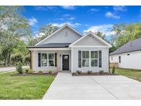 Charming one-story home featuring black shutters, craftsman columns, and a well-manicured lawn at 401 N Raiford St, Selma, NC 27576
