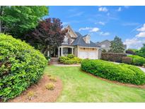 Beautiful two-story home featuring a well-manicured lawn, mature trees, and a two-car garage at 404 Brightling Way, Holly Springs, NC 27540