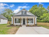 Charming white cottage-style home with black shutters, wood columns, and well-manicured lawn at 405 N Raiford St, Selma, NC 27576