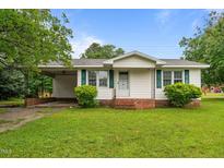 Charming home with a well-maintained lawn, white siding, and green shutters at 407 W Depot St, Angier, NC 27501