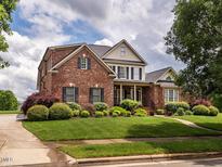 Charming two-story brick home featuring well-maintained landscaping and a lush green lawn at 4266 Aviemore Run, Burlington, NC 27215