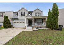 Charming two-story home featuring a covered porch, two-car garage and manicured lawn at 4621 Youngsbury Ct, Raleigh, NC 27604