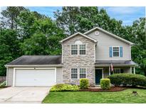 Charming two-story home with stone accents, blue shutters, and a well-manicured front yard at 5410 Pageford Dr, Durham, NC 27703