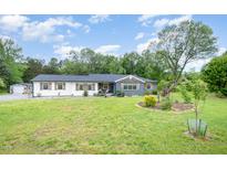 Charming single-story home with a landscaped front yard and detached garage at 553 Isley Rd, Haw River, NC 27258