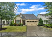 Charming home boasts manicured lawn, two-car garage, and inviting curb appeal on a sunny day at 79 Heatherwood Dr, Chapel Hill, NC 27516