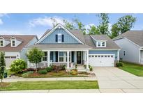 Charming home with a welcoming front porch, well-manicured landscaping, and a convenient two-car garage at 805 Narrative Ln, Durham, NC 27703