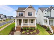 Charming two-story home with a welcoming front porch and landscaped front yard at 825 Abbyberry Dr, Wake Forest, NC 27587
