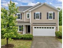 Charming two-story home with a two car garage, manicured lawn and beautiful, mature landscaping at 831 Poplar St, Durham, NC 27703