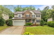 Charming two-story home with a stone and siding exterior and well-manicured lawn at 9013 Dansforeshire Way, Wake Forest, NC 27587