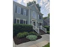Charming two-story home featuring a manicured lawn, white-trimmed windows, and an inviting entrance with a decorative wreath at 103 Chapelwood Way, Cary, NC 27518