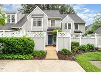 Charming two-story home featuring a well-maintained yard, a welcoming blue front door, and a white picket fence at 113 Spring Cove Dr, Cary, NC 27511
