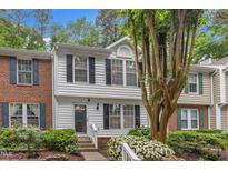 Charming townhouse with white siding, black shutters, and lush landscaping at 134 Riverwalk Cir, Cary, NC 27511