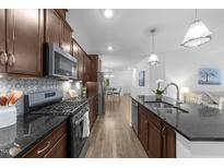 Modern kitchen features stainless steel appliances, dark granite countertops, and hardwood floors at 143 Swain St, Clayton, NC 27527