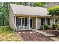 Inviting home exterior with charming front porch, manicured landscaping, and neutral siding at 17 Crystal Oaks Ct, Durham, NC 27707