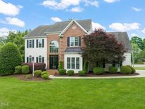 Beautiful two-story home with brick and siding, manicured lawn, and mature landscaping at 2000 Katesbridge Ln, Raleigh, NC 27614