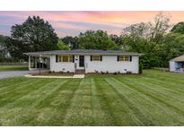 Charming single-story home with freshly cut lawn, brick stairs, and manicured landscaping at 2205 W Carver St, Durham, NC 27705