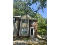 Charming two-story townhome with brick accents and plentiful windows, set amidst mature trees and a well-maintained lawn at 225 Virens Drive, Cary, NC 27511