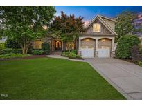 Charming home boasts a well-manicured lawn, stone accents, two car garage and mature trees, creating a welcoming curb appeal at 2507 Mayview Rd, Raleigh, NC 27607