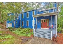 Unique blue home exterior with beautiful landscaping, a porch swing, and a welcoming front entrance at 2525 Buxton Ct, Chapel Hill, NC 27514