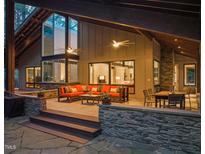 Inviting covered patio with stone accents, ceiling fans and comfortable seating area at 2721 Silver Stirrup Ln, Apex, NC 27502