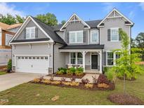 Inviting two-story home showcasing a two-car garage, gray siding, manicured landscaping, and a charming front porch at 3625 Bailey Lake Dr, Fuquay Varina, NC 27526