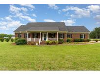Charming brick home with a welcoming front porch and well-manicured lawn at 5136 Liberty Grove Rd, Liberty, NC 27298