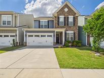 Charming two-story home featuring a stone and siding facade with a two-car garage and well-manicured lawn at 524 Rowanwood Way, Apex, NC 27523