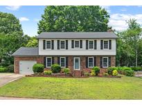 Charming two-story brick home with black shutters, a manicured lawn, and beautiful landscaping at 5409 Knollwood Rd Rd, Raleigh, NC 27609