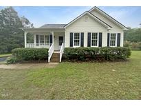 Charming home with manicured lawn and a welcoming front porch with stairs at 5749 Stone Crystal Dr, Fuquay Varina, NC 27526