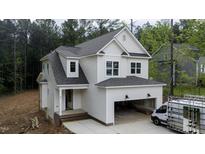 New construction home with white siding, covered garage, and brick-lined front porch at 60 Purslane Dr, Franklinton, NC 27525