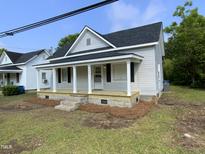 Charming single-Gathering home with a covered front porch and fresh landscaping details at 609 N Magnolia Ave, Dunn, NC 28334