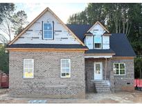 New construction home featuring a brick facade, black roof, and bright windows awaiting finishing touches at 824 Emmett Ct, Spring Hope, NC 27882