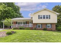 Charming two-story home featuring a brick and siding facade, complemented by a well-manicured lawn at 1000 Winona Rd, Raleigh, NC 27609