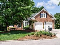 Charming brick home with manicured lawn, mature trees, and two-car garage offering curb appeal and classic design at 101 Temple Gate Dr, Cary, NC 27518