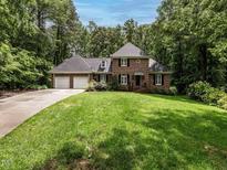 Beautiful brick home with manicured lawn, attached two-car garage, and mature trees at 104 Deer Park Ln, Cary, NC 27518