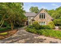 Stunning stone-clad home featuring a brick driveway and mature landscaping at 10405 Veasey Mill Rd, Raleigh, NC 27615