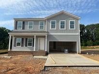 Two-story home with light gray siding, double garage, and covered front porch at 110 Cordoba Dr, Franklinton, NC 27525