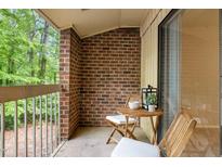 Cozy balcony featuring brick detail, outdoor seating, and sliding glass door access at 1200 Schaub Dr # G, Raleigh, NC 27606
