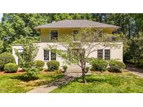 Charming two-story home featuring a well-manicured lawn, mature trees, and a welcoming entrance at 1217 Aycock Ave, Burlington, NC 27215