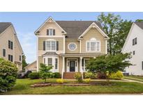 Charming two-story home with detailed trim, manicured lawn, and a welcoming front porch at 128 Low Country Ct, Morrisville, NC 27560