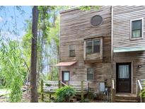 View of a rustic, multi-story townhouse with weathered wood siding and a small deck at 130 E Longview St # Apt S, Chapel Hill, NC 27516