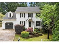 Charming two-story home with a brick facade, black shutters, and well-manicured landscaping at 1312 Stonemoor Ct, Raleigh, NC 27606
