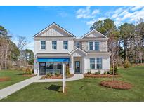 Stunning two-story home featuring a brick and stone facade, a well-manicured lawn, and a DRB Homes sales office at 147 Sugar Pine Drive, Franklinton, NC 27525