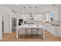 Bright, open kitchen features a large island with seating and stainless steel appliances at 148 Sugar Pine Drive, Franklinton, NC 27525
