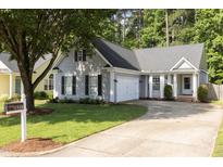 Charming home with gray siding, mature tree, and well-manicured lawn and driveway at 1816 Piperwood Ct, Durham, NC 27713
