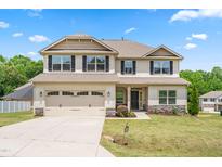 Charming two-story home featuring a two-car garage, well-manicured lawn, and classic curb appeal at 222 Trailing Oak Trl, Clayton, NC 27527