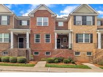Brick townhome with black shutters and a well-manicured lawn at 231 Grindstone Dr, Apex, NC 27502